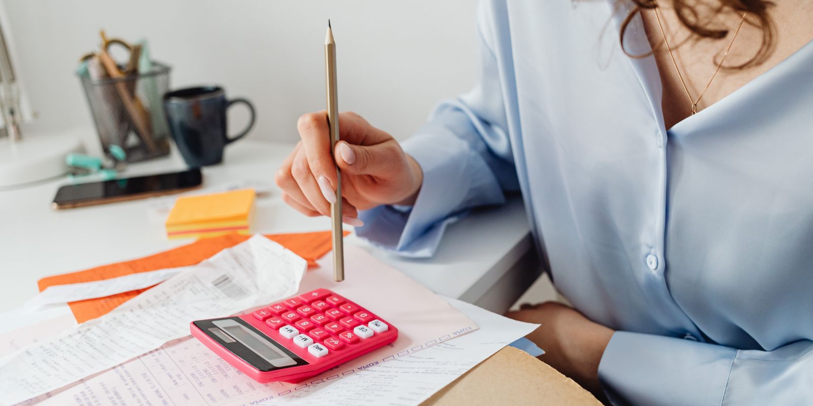 Working through bills and receipts with a calculator at a desk